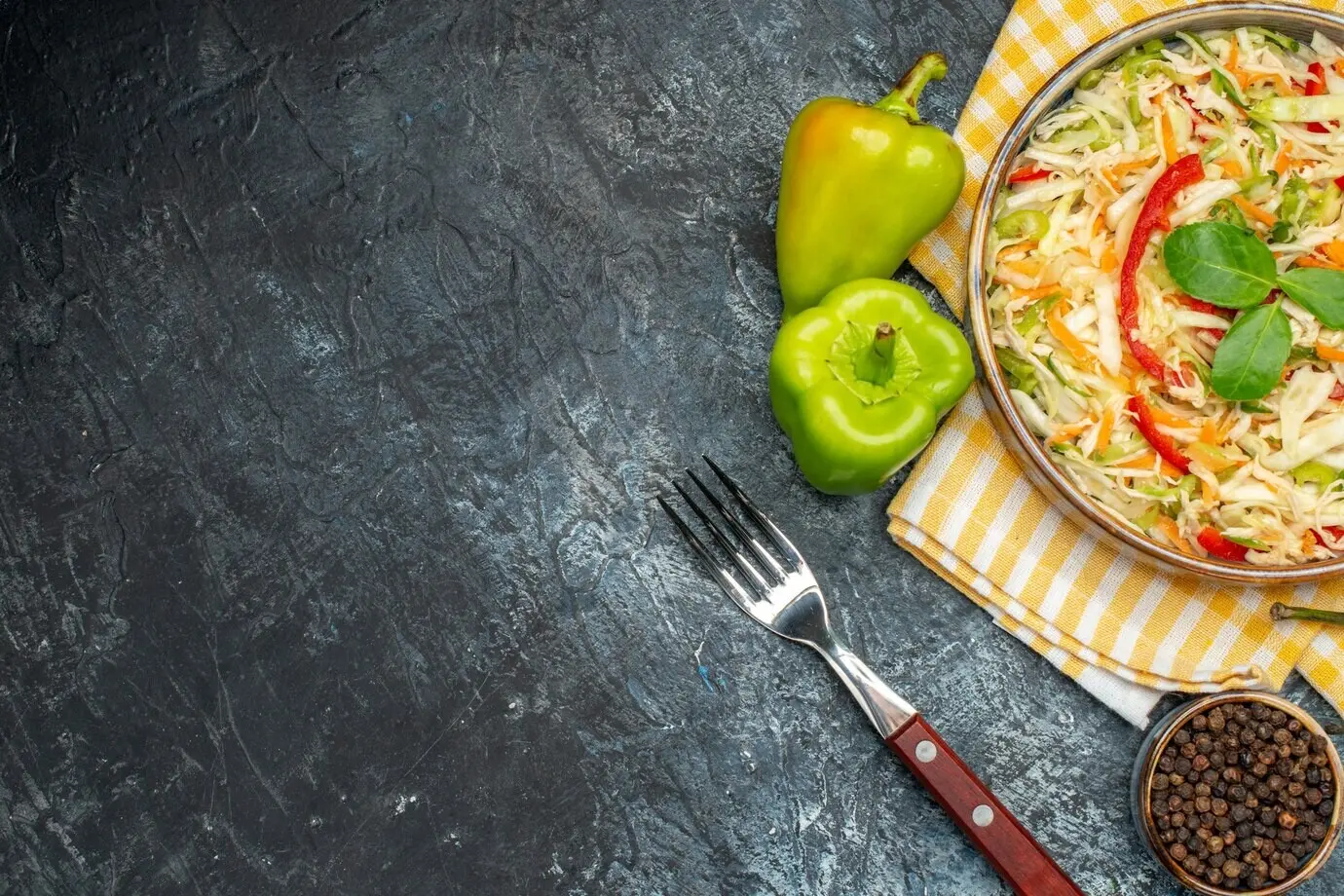 Ansicht von oben auf einen Gemüsesalat auf einer dunklen Oberfläche